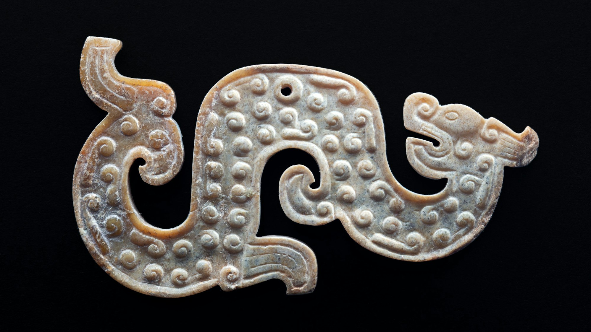 Ein Drache liegt gemütlich auf schwarzem Grund.