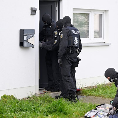 Polizisten durchsuchen in der Nähe der Innenstadt Wohnungen und Häuser im Rahmen einer Razzia gegen Schleuserkriminalität.