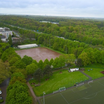 Das Luftbild zeigt einen Aschenplatz und einen Kunstrasenplatz, im Hintergrund die Autobahn und den Grüngürtel.