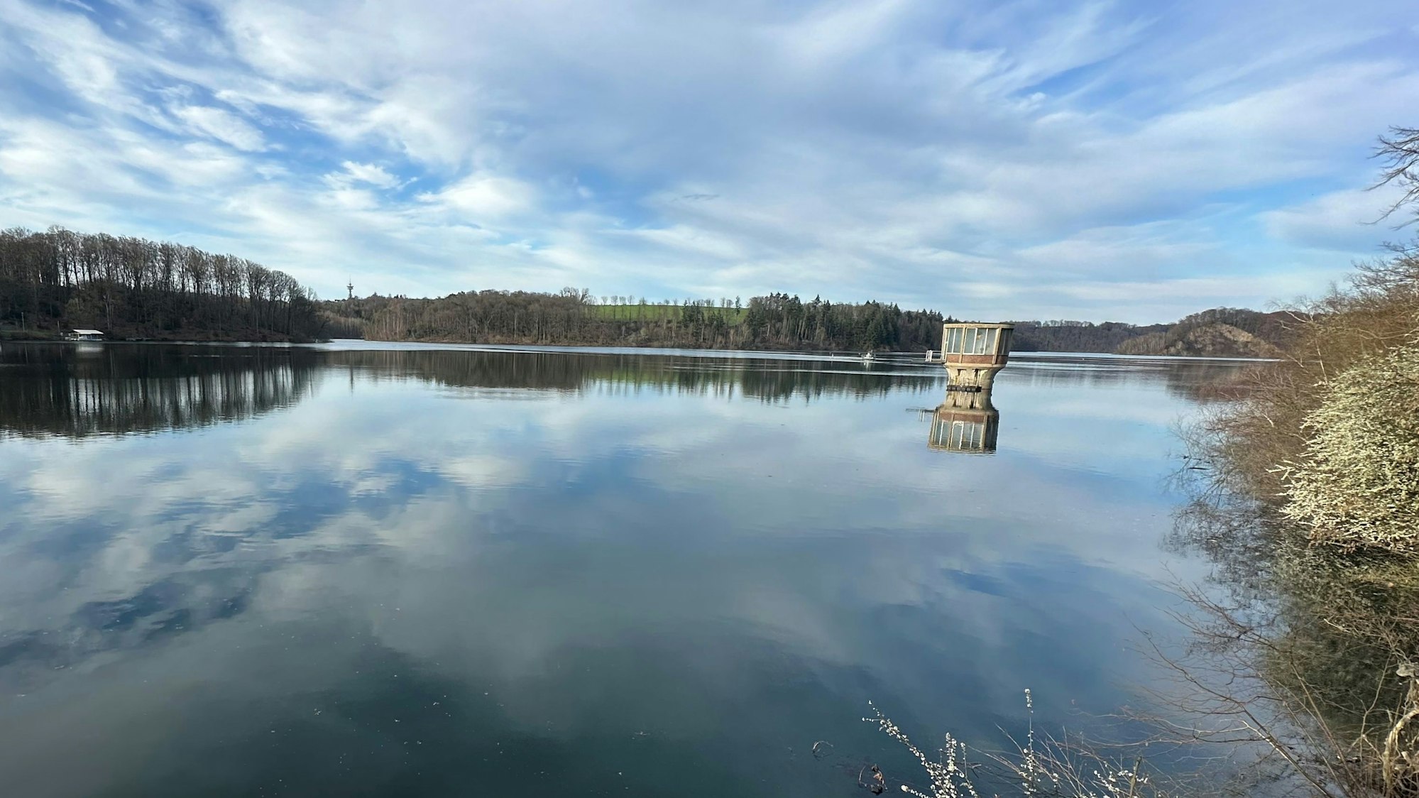 Wolken spielen sich im Wasser einer Talsperre