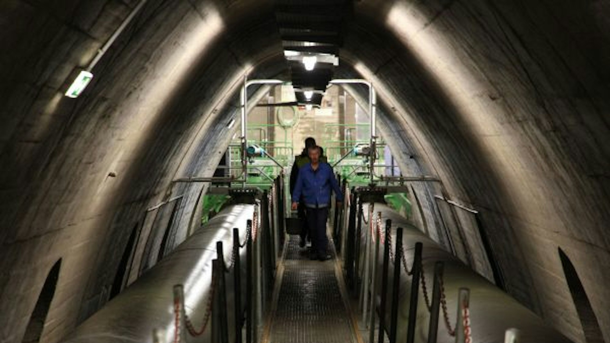Besucher in einem Gewölbe mit einem Gang im Inneren eines Staudamms