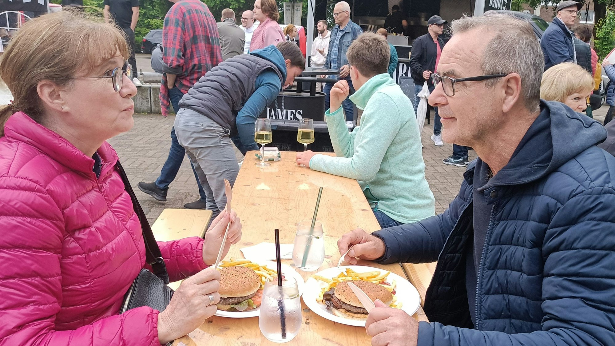 Zwei Menschen essen Burger.