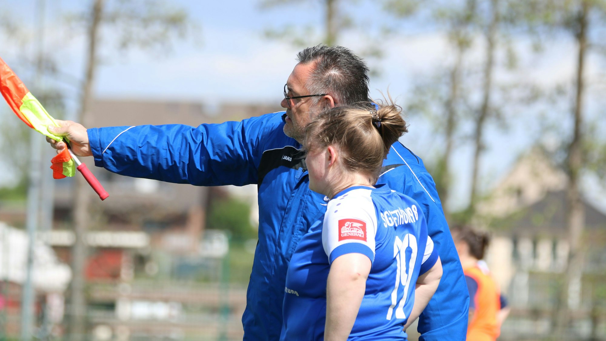 Markus Lingscheid mit einer Spielerin bei der Einwechslung. In der Hand hält er die Assistenten-Fahne.