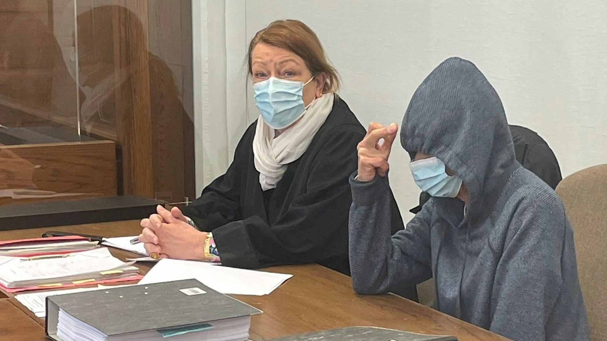 Prozess in der Corona-Zeit: Die Maske hilft der Angeklagten, ihr Gesicht vor Fotografen zu verstecken. Sie muss sich wegen der Tötung ihres Bruders verantworten. Neben ihr sitzt ihre Anwältin Ulrike Tasic.