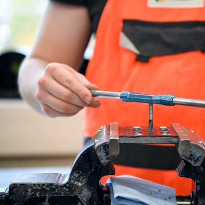 Lehrling an einem Schraubstock.