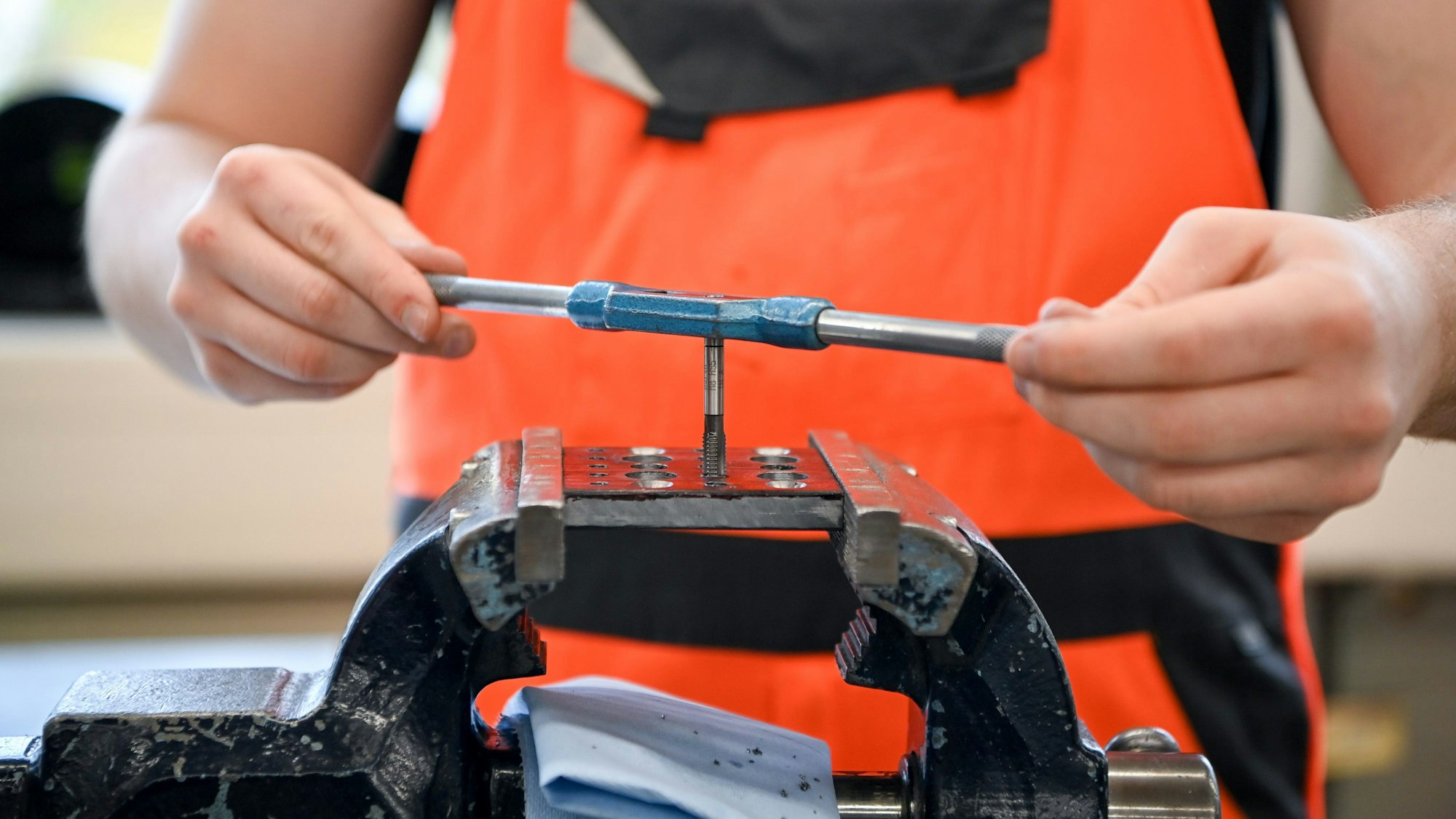 Lehrling an einem Schraubstock.