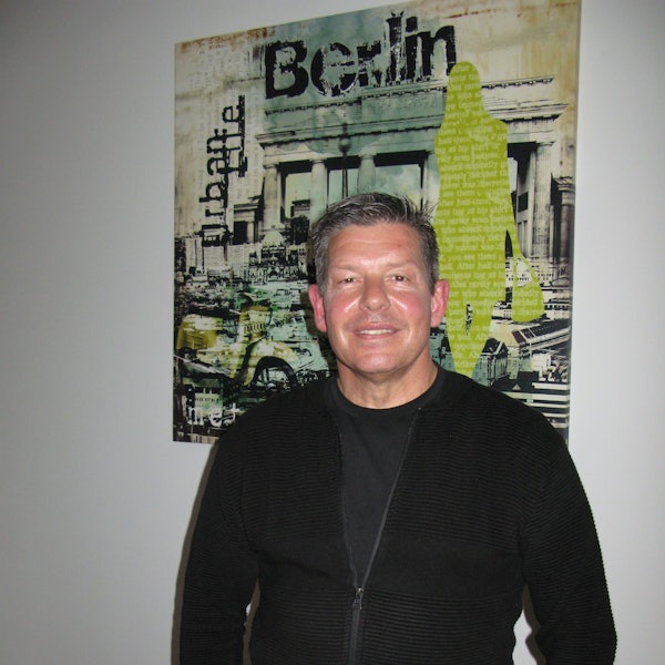 Ein Mann steht vor einem Plakat.