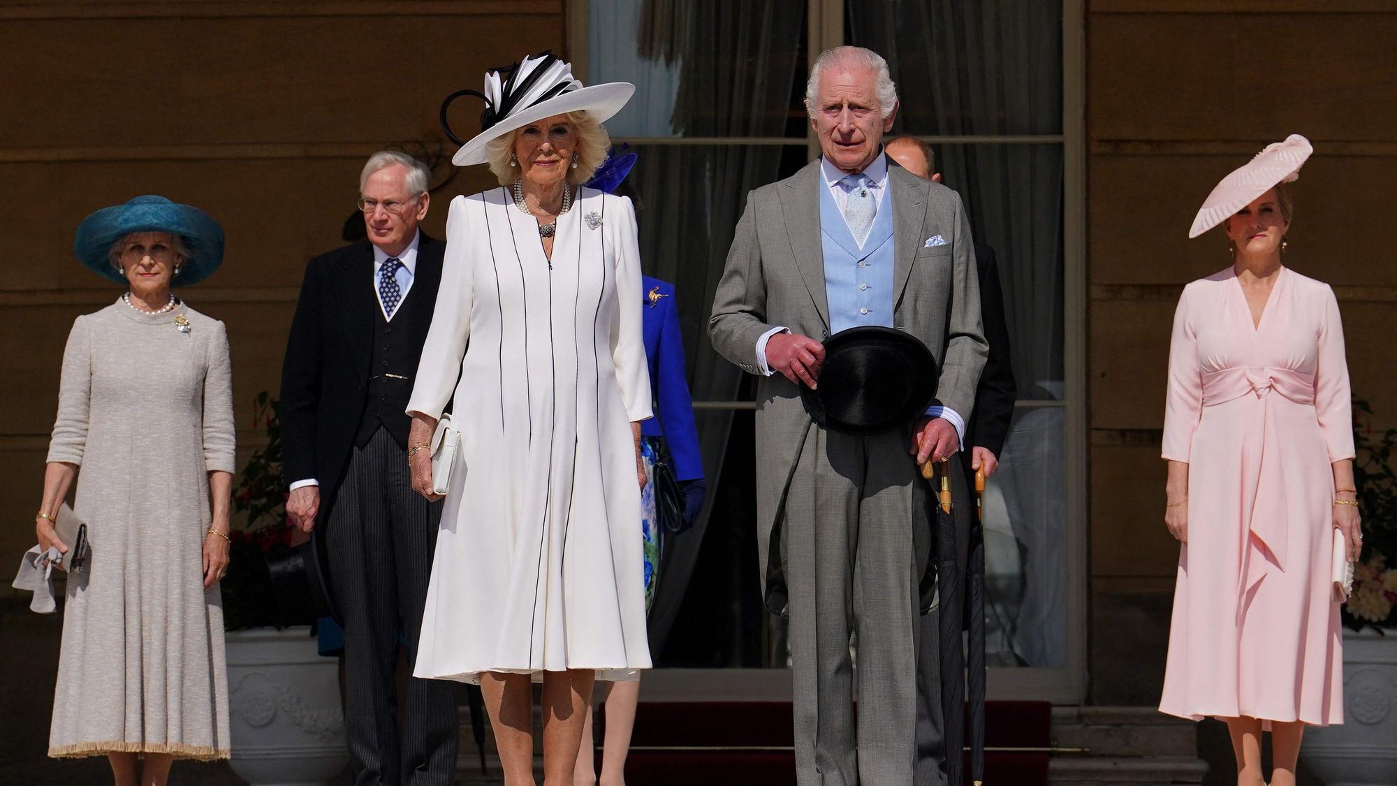 Königin Camilla und König Charles stehen im Garten.