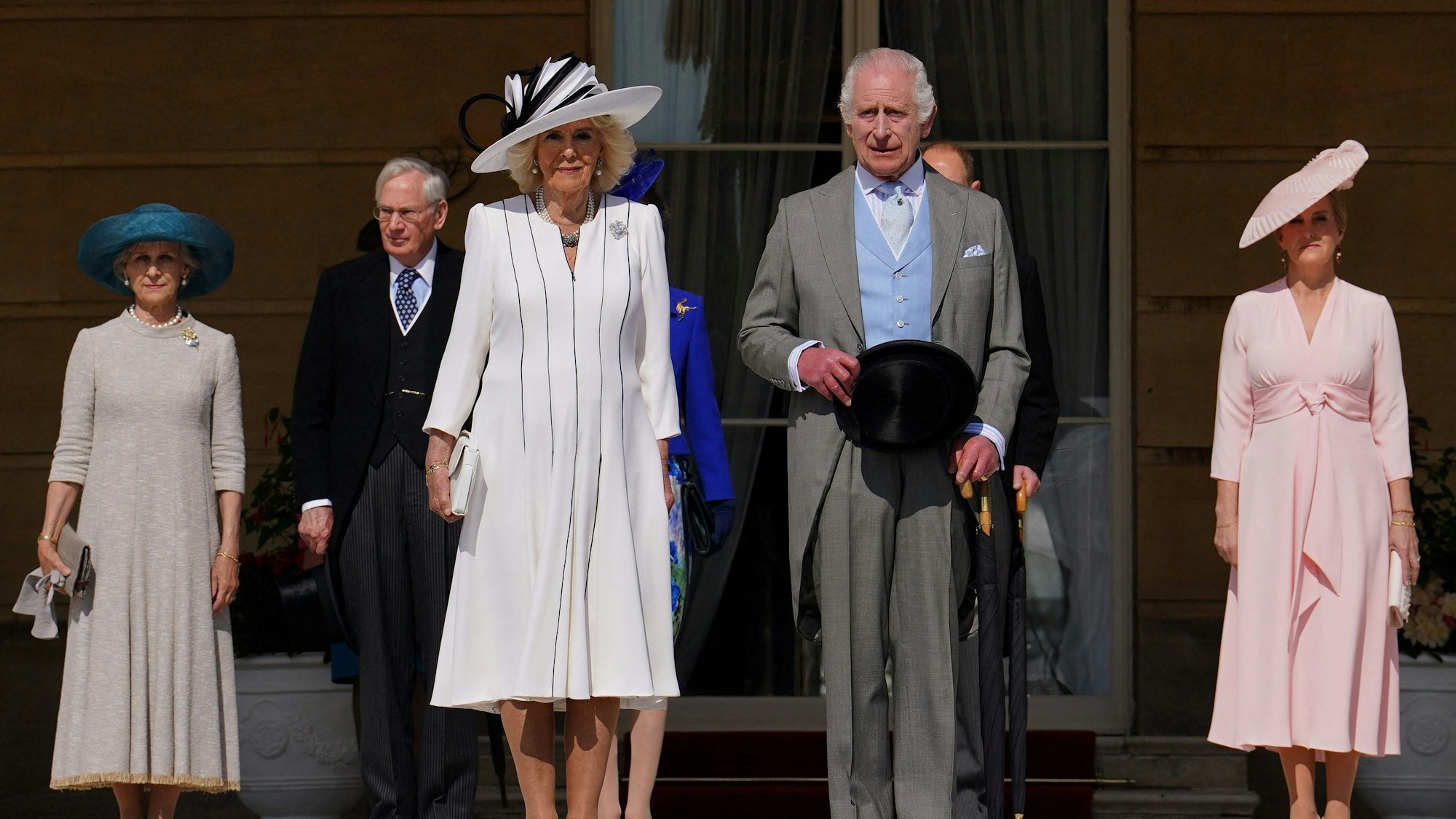 Königin Camilla und König Charles stehen im Garten.