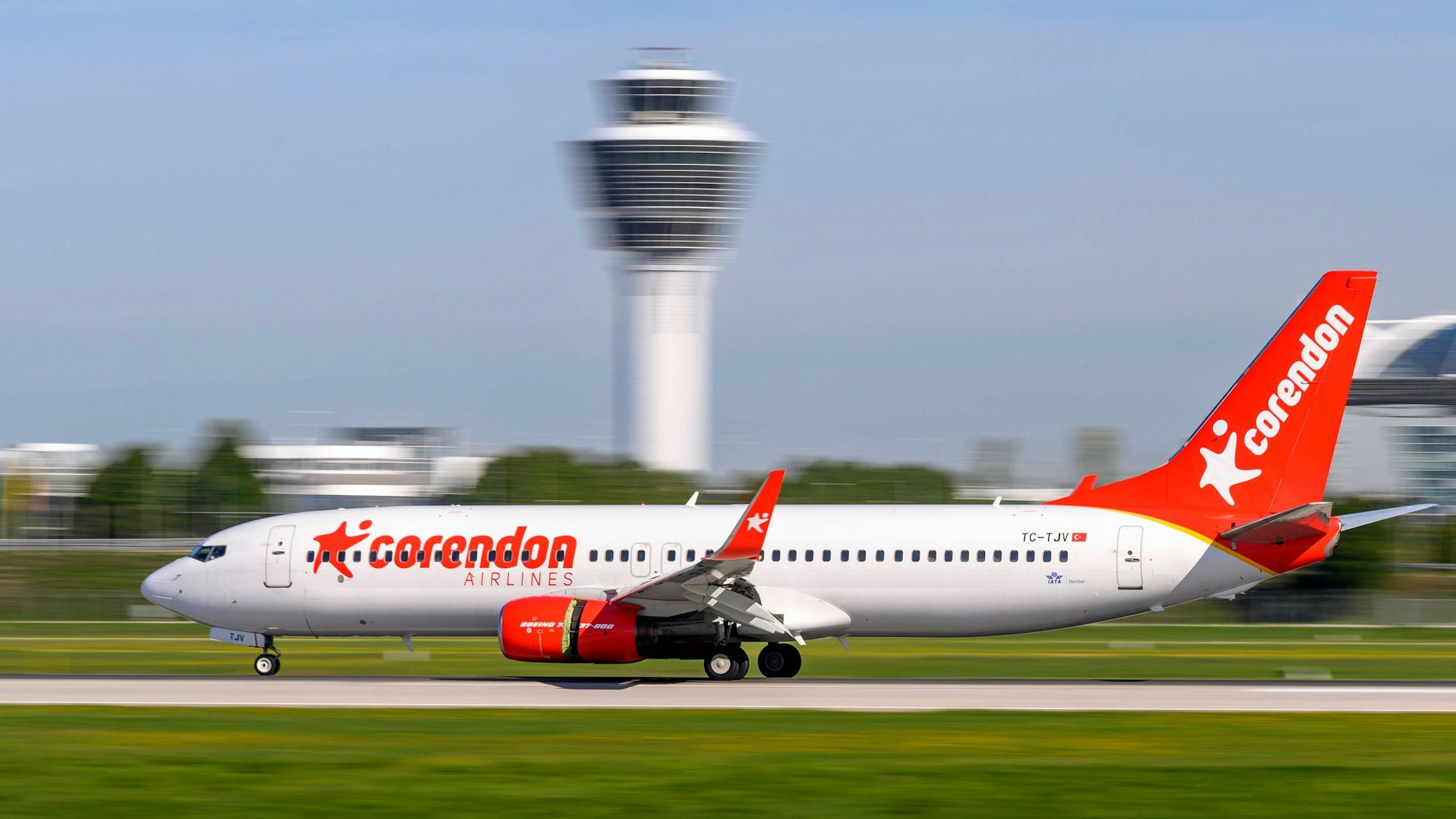 Eine Boeing 737 der türkischen Billigfluggesellschaft Corendon Airlines beim Landeanflug in hoher Geschwindigkeit vor einem Tower eines Flughafens. (Symbolbild)