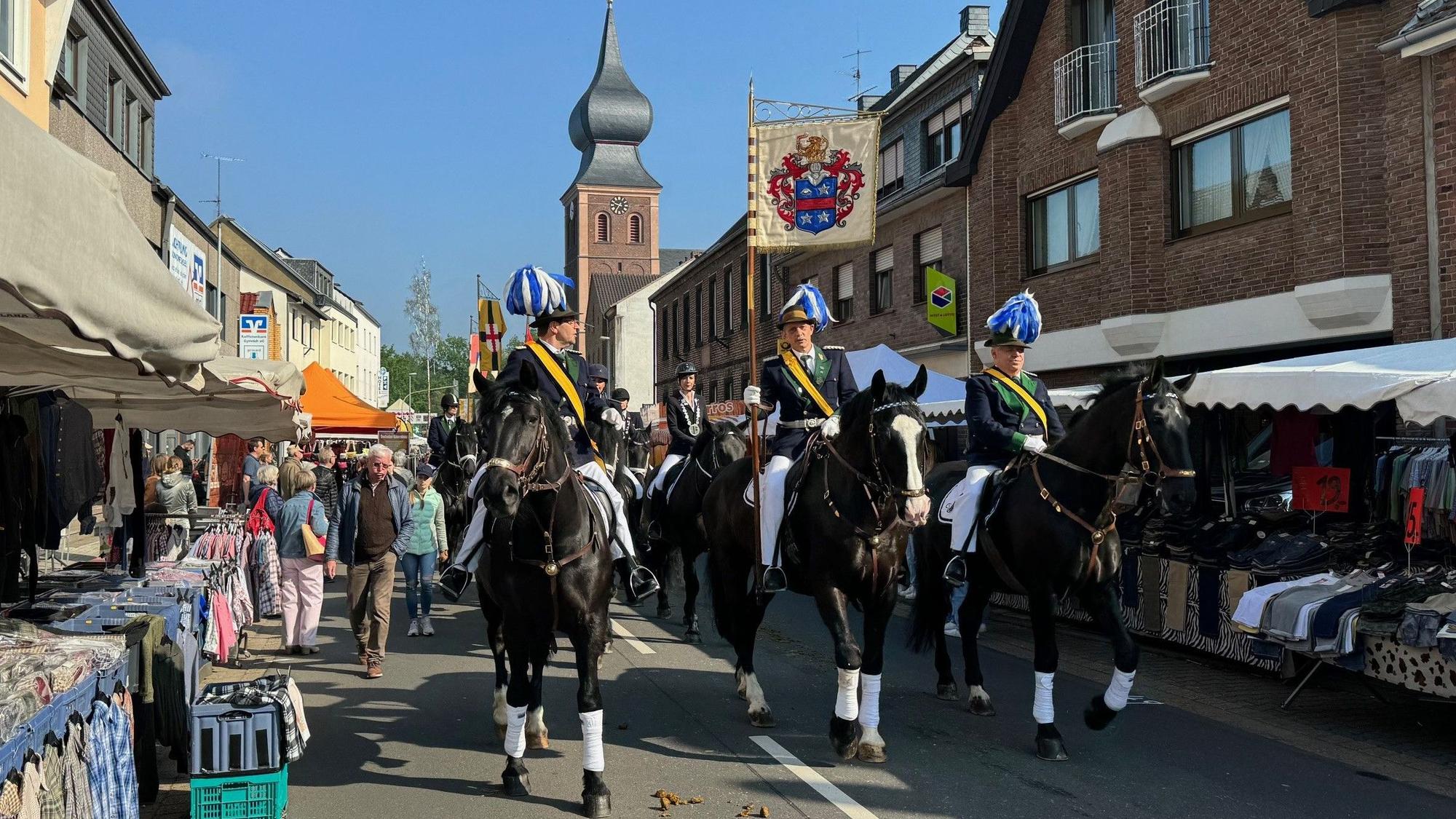 Das Bild zeigt Schützen auf Pferden, die durch Gymnich reiten.