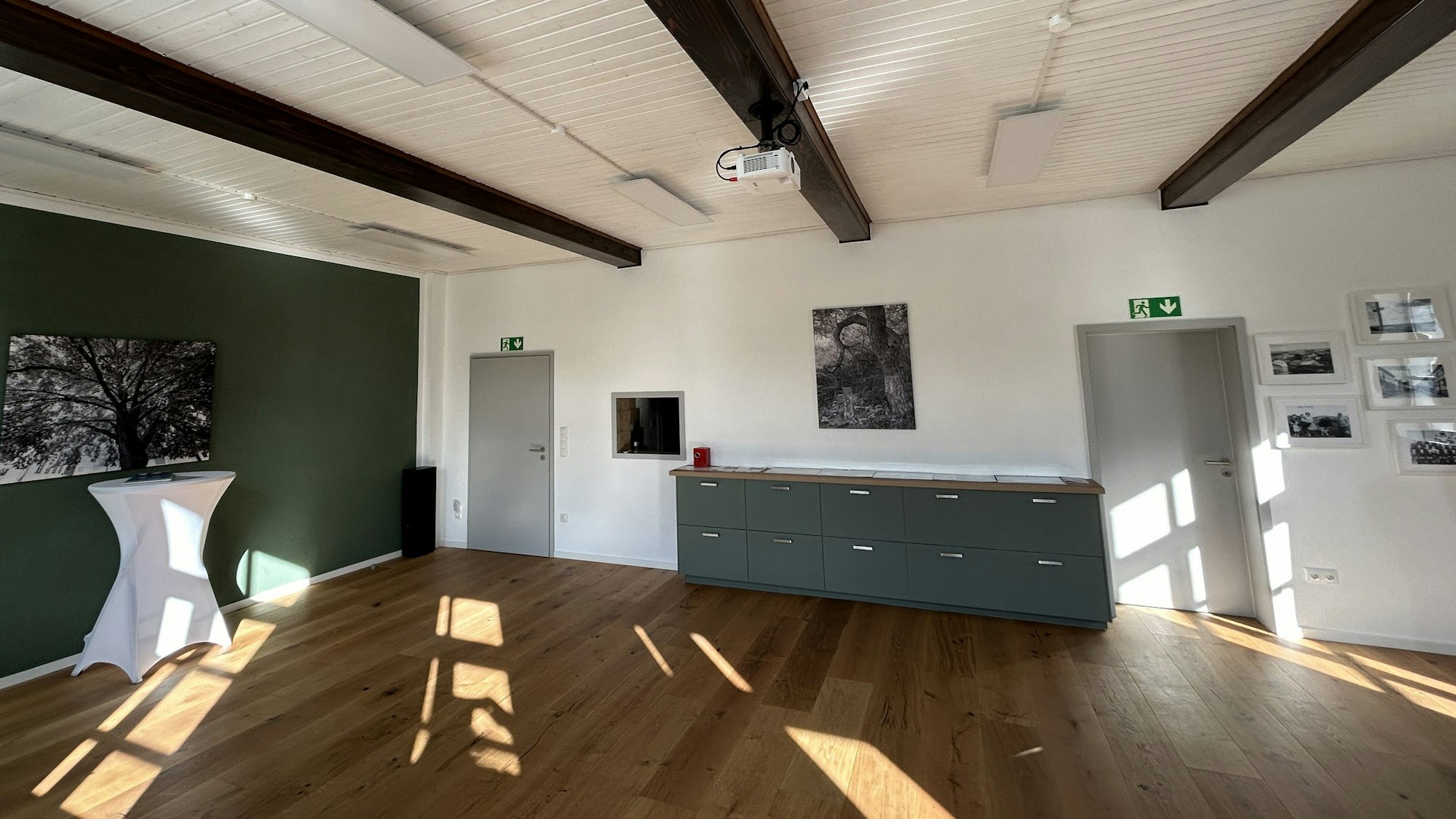 Das Bild zeigt den Blick in den leeren Saal, der einen neuen Holzboden hat.