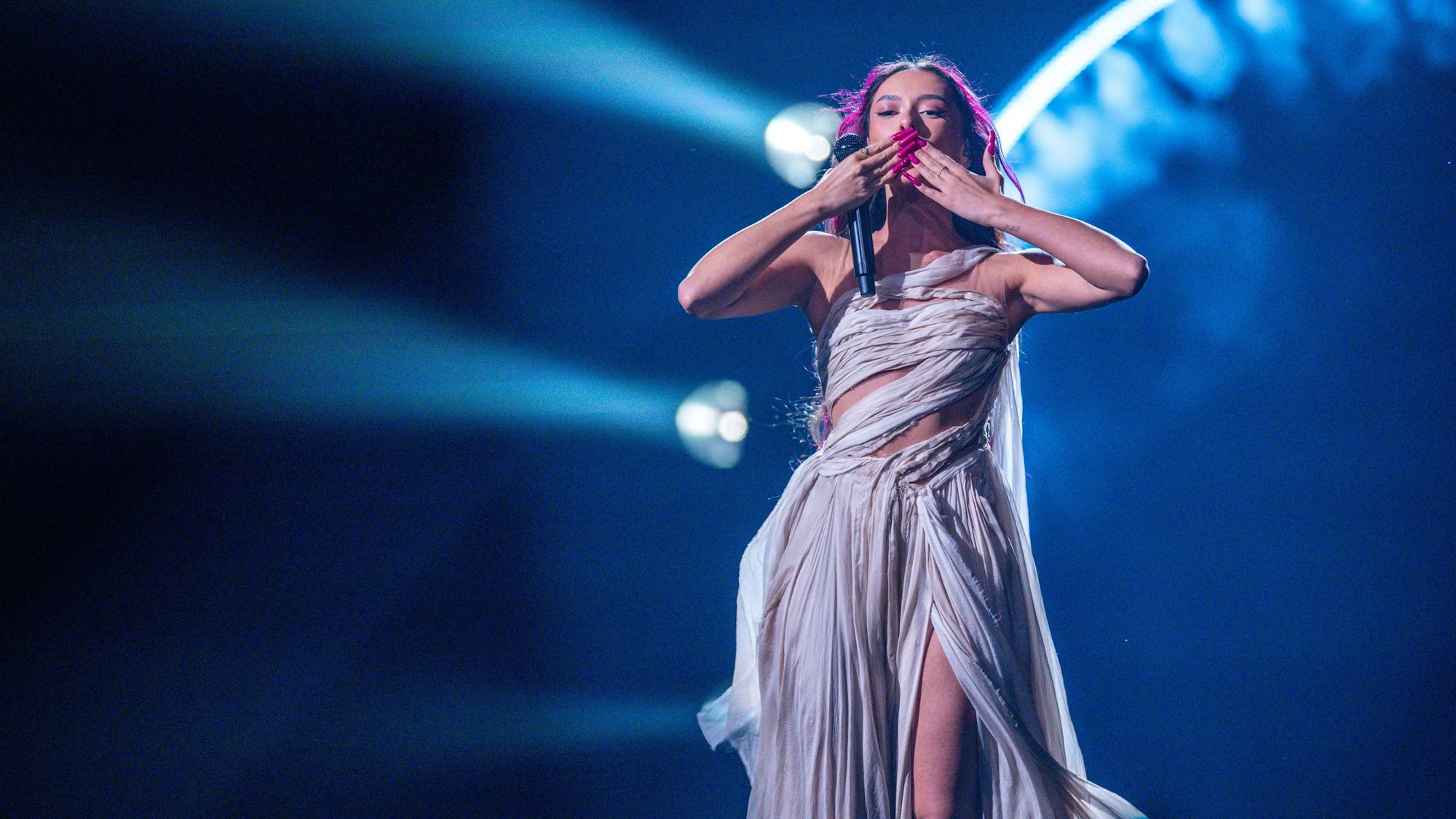 Eden Golan trägt ein Kleid aus vielen zusammengerollten Tüchern und richtet eine Kussgeste zu den Fans