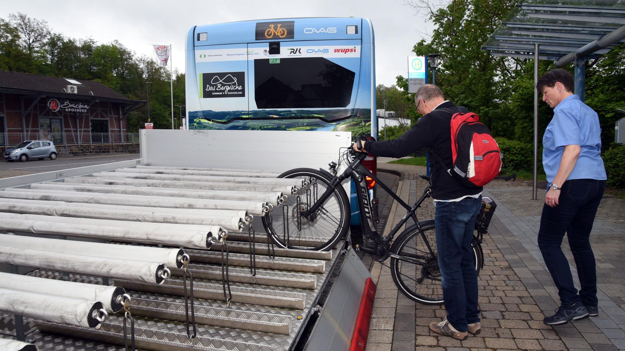 Ein Mann lädt sein Fahrrad auf den Anhänger eines Fahrradbusses.
