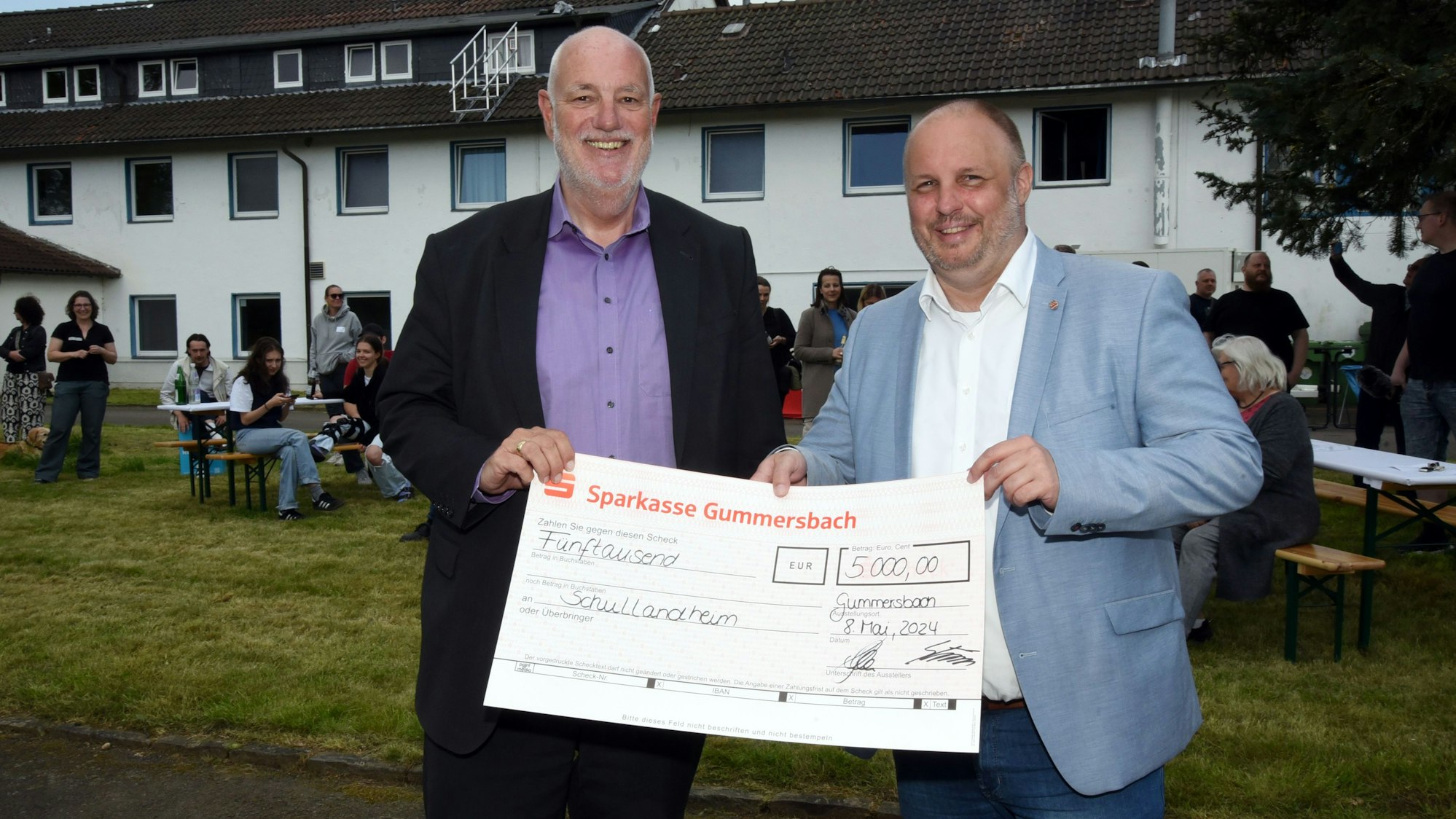 Scheckübergabe zwischen zwei Männern