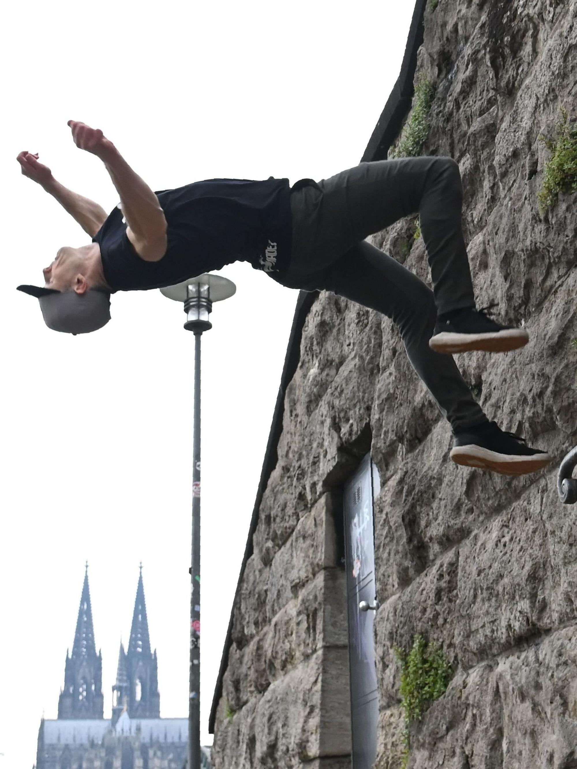 Ein Mann setzt zum Salto von einer Wand aus an