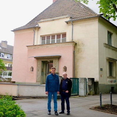 BU: Holger Fiedler (l.) und Friedhelm Hilgers vor dem leerstehenden Wohnhaus der Universität an der Lindenburger Allee 15.