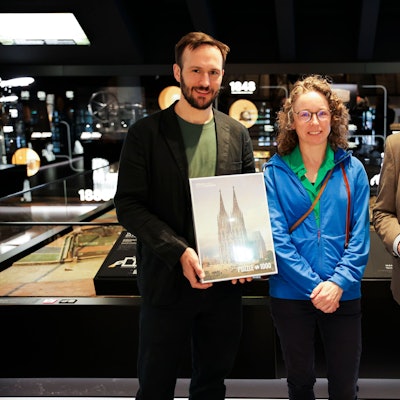 Kurator Sascha Pries (l.) und Direktor Matthias Hamann begrüßen die 15.000ste Besucherin des Kölner Stadtmuseums.
