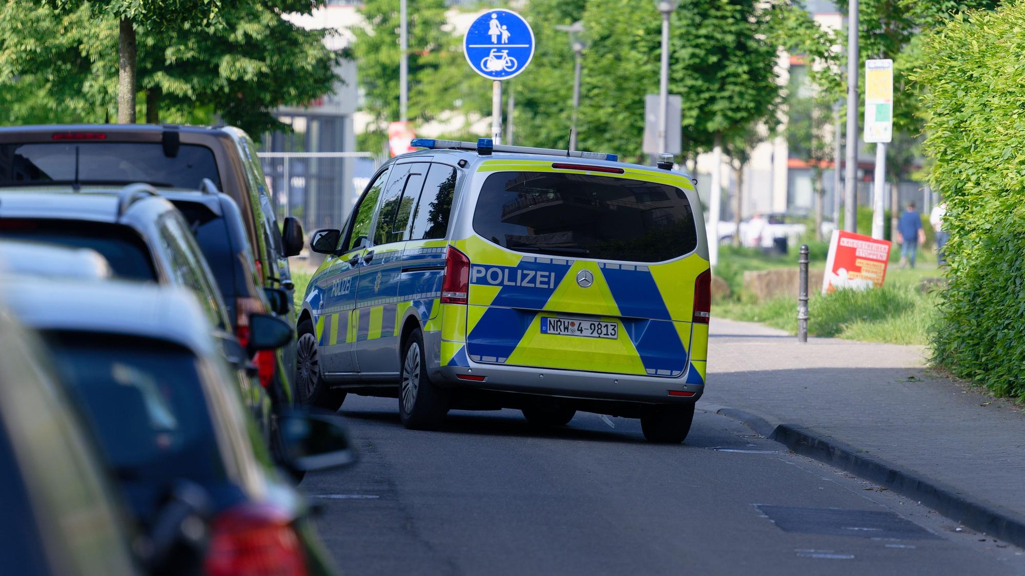 Ein Polizeiauto steht am Samstag in einer Straße am Rand des Bürgerparks in Köln-Kalk.