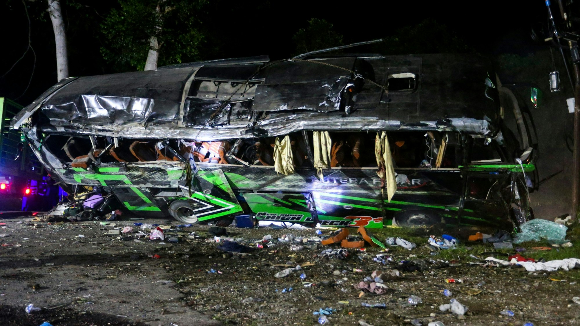 Das Wrack eines Busses liegt nach einem Unfall am Straßenrand.