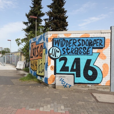 Von der Widdersdorfer Straße aus sieht und hört man den Club. Man hat keinen Zutritt auf das Privatgelände, auf dem sich der neue Club „Fi“ verbirgt.