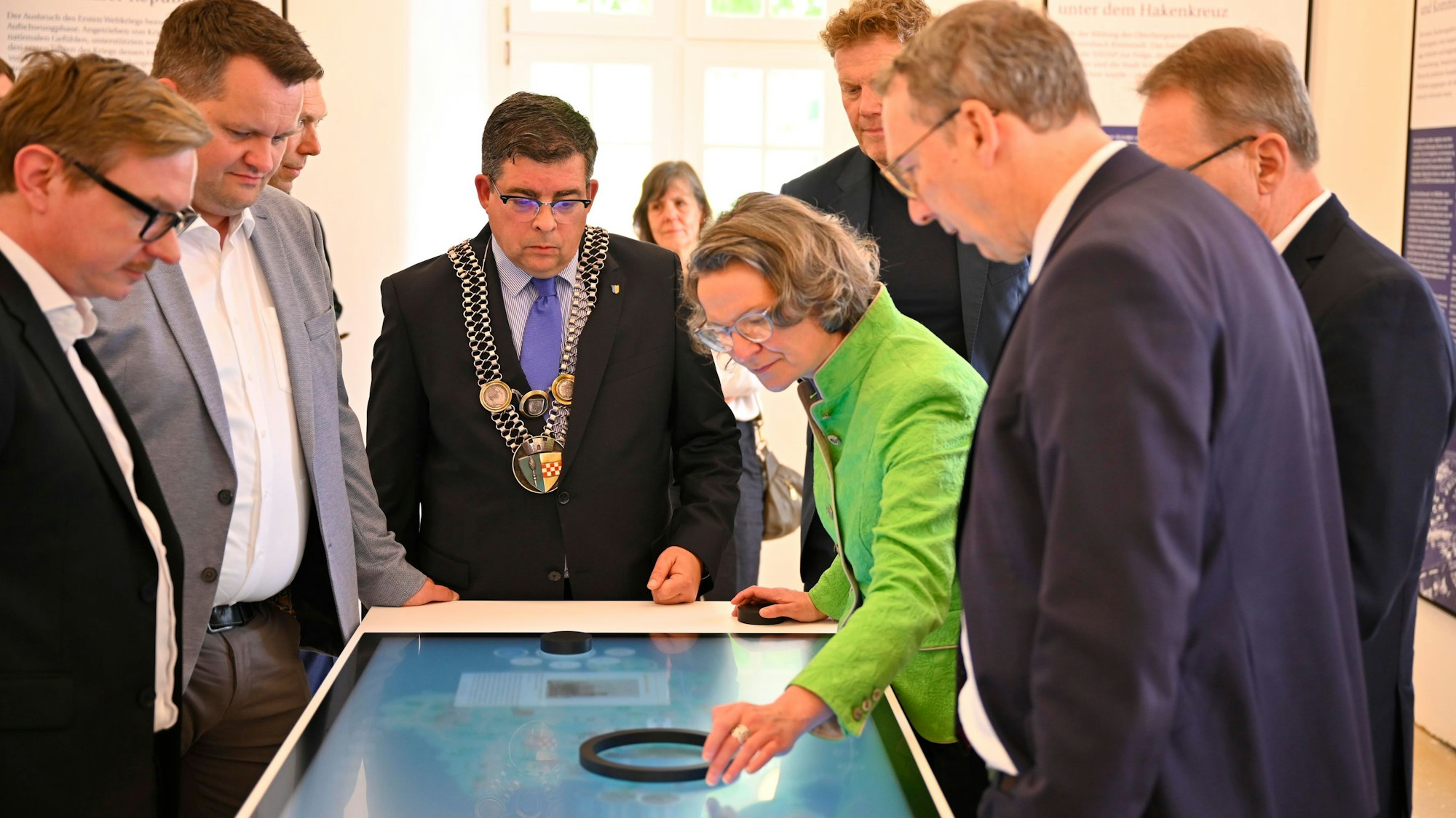 Blick auf eine Gruppe von Menschen an einer digitalen Infotafel