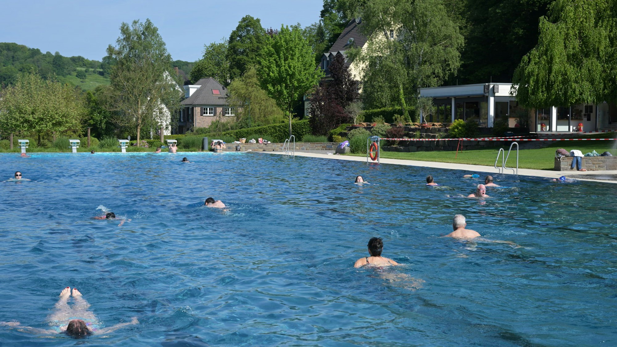 Mehrere Schwimmer ziehen ihre Bahnen im Schwimmbecken eines Freibads.
