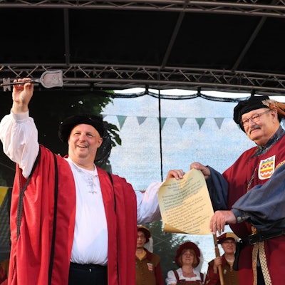 Ein Mann überreicht dem anderen einen Schlüssel.