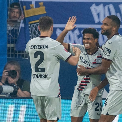 Bayer-Profi Amine Adli (M) jubelt mit den Teamkollegen Josip Stanisic (l) und Jonathan Tah über sein Tor zum 0:3.