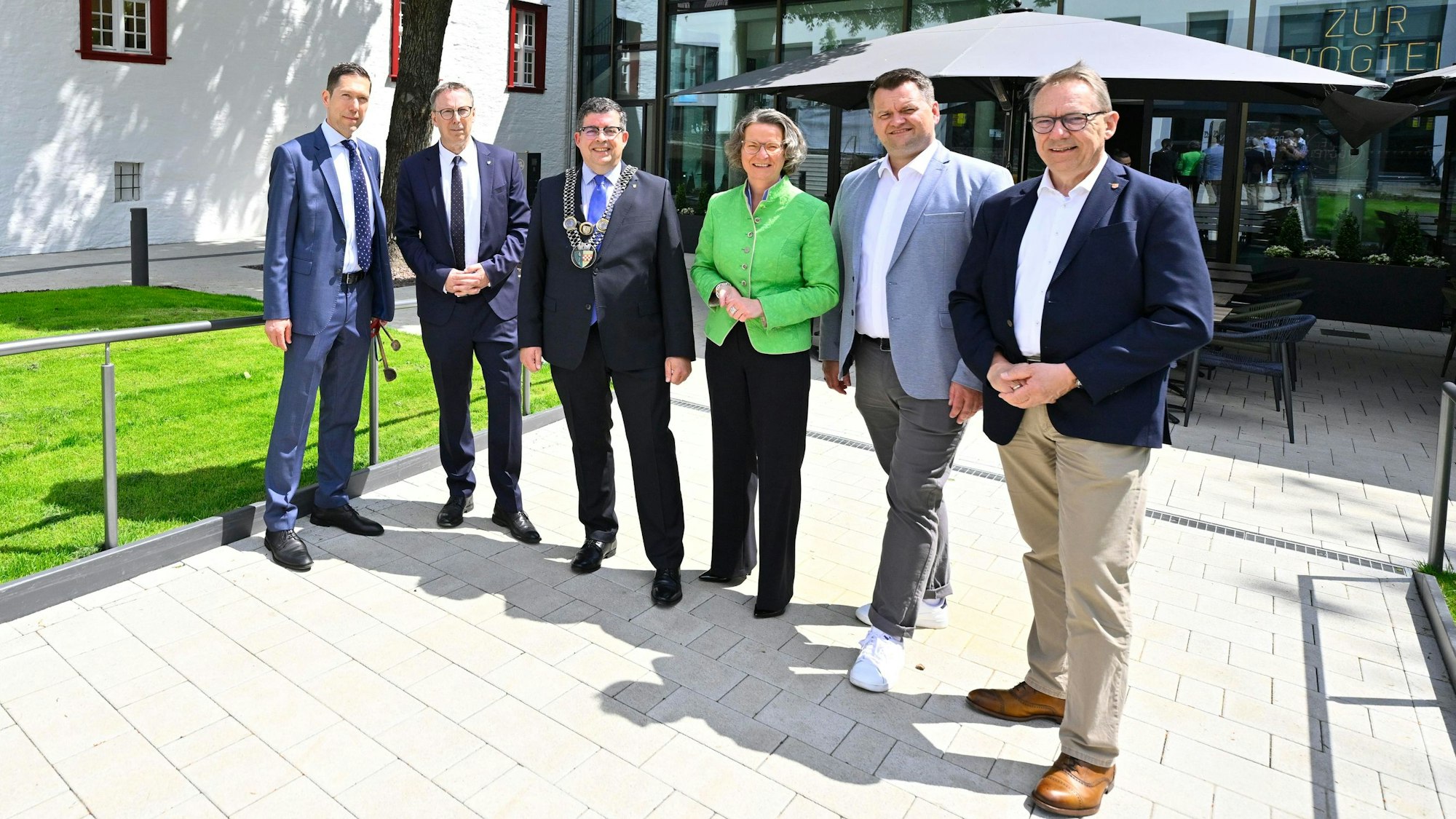 Blick auf eine Männergruppe mit Frau in der Mitte