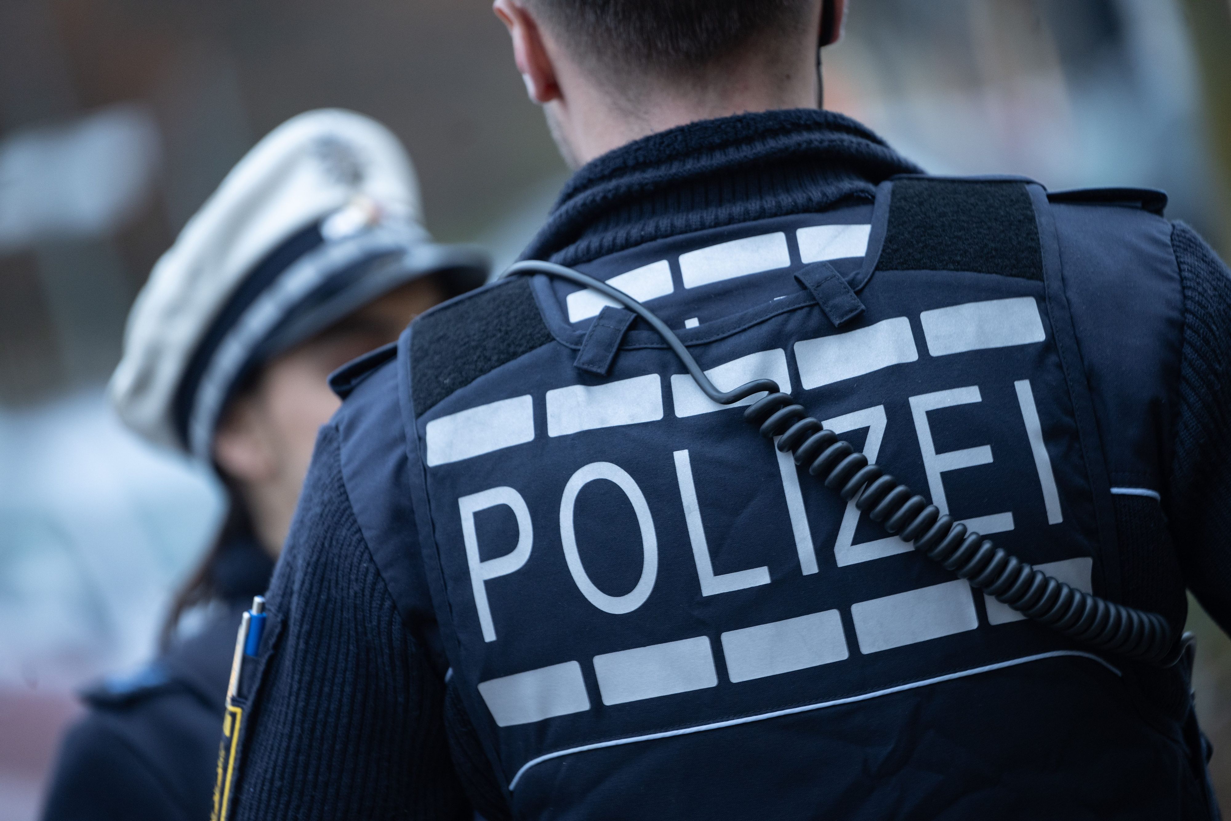 Eine Polizistin (l) und ein Polizist gehen im Rahmen eines Fototermins eine Straße entlang.