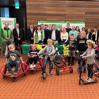 Das Bild zeigt Vertreter aus den Schulen und Kitas sowie der Verkehrswacht und Sponsoren. Zudem sind Kinder zu sehen, die die neuen Spielgeräte testen.