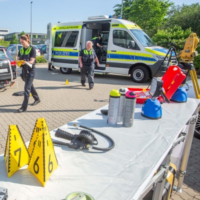 Polizisten arbeiten an einem Auto, das über ein Fahrrad gefahren ist.