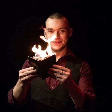 Ein Mann hält ein brennendes Buch.