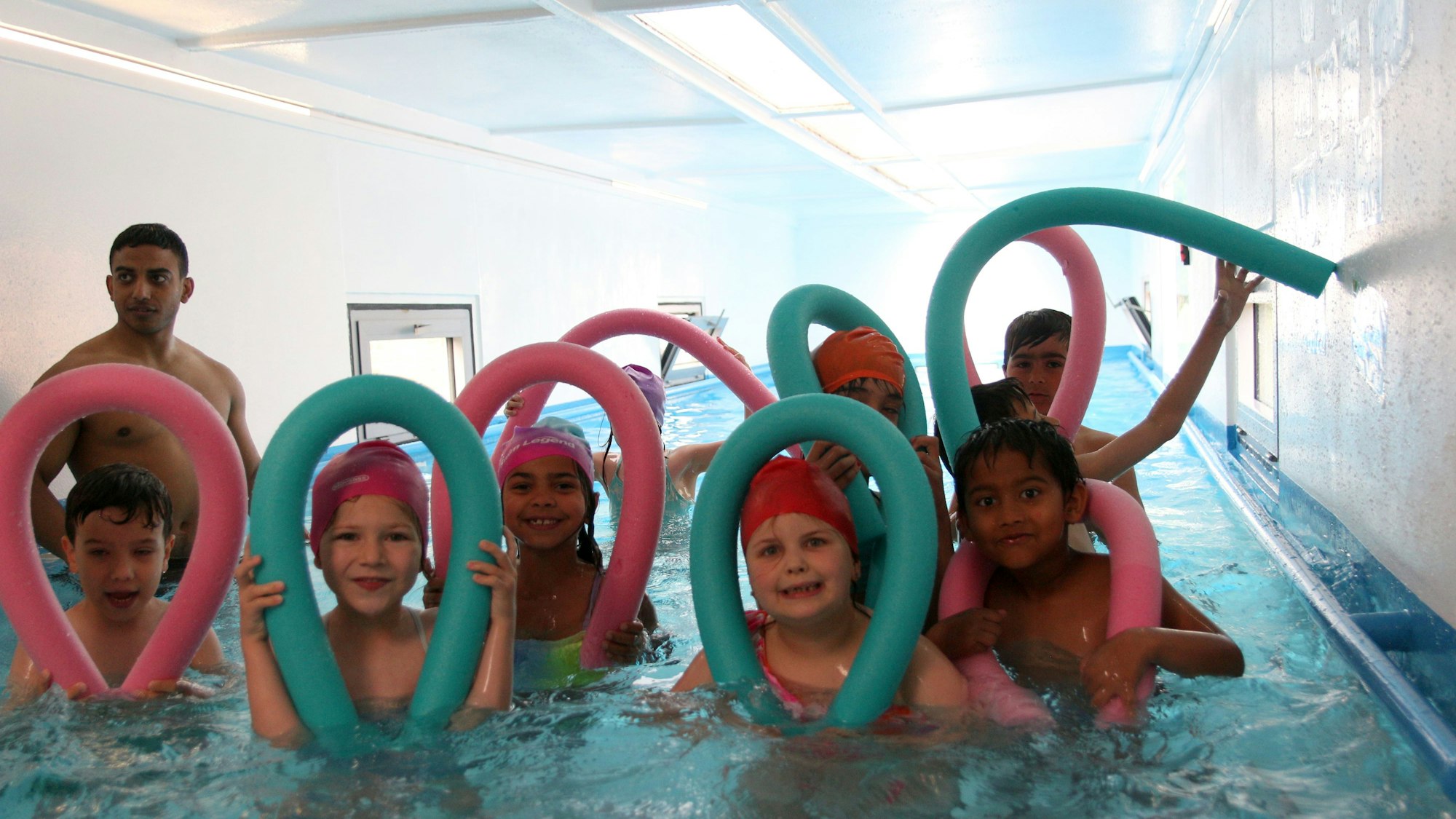 Auf dem Bild sind Kinder zu sehen, die den Schwimmcontainer nutzen.