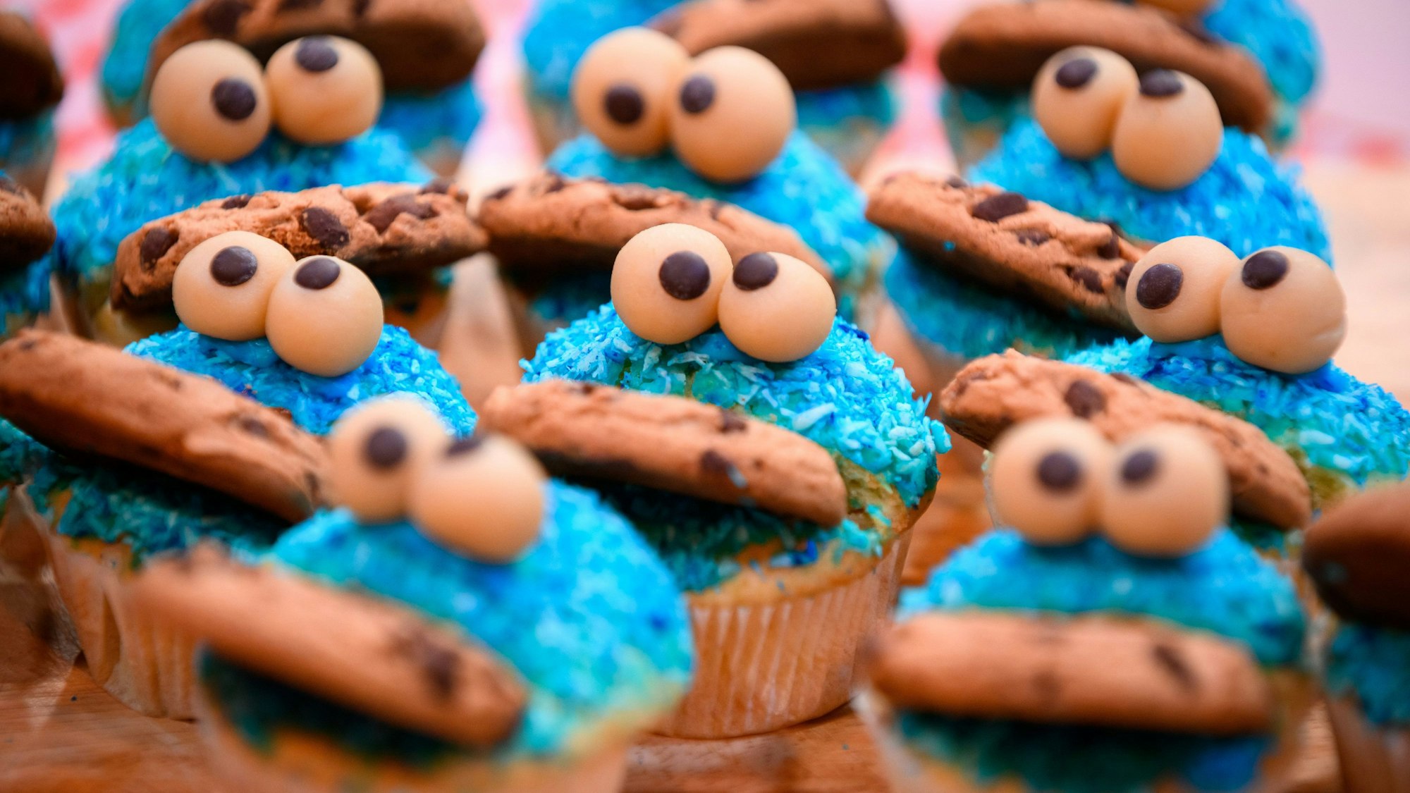 Zu sehen sind Muffins in Form des Krümelmonsters aus der Sesamstraße mit einem Keks im Mund.