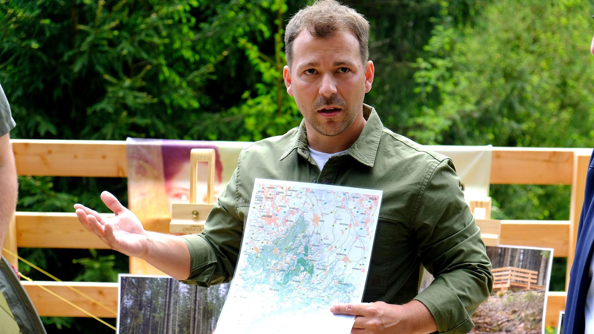 Peter Gieseler mit einer Karte, auf der die Standorte der Trekking-Plattformen eingezeichnet sind.