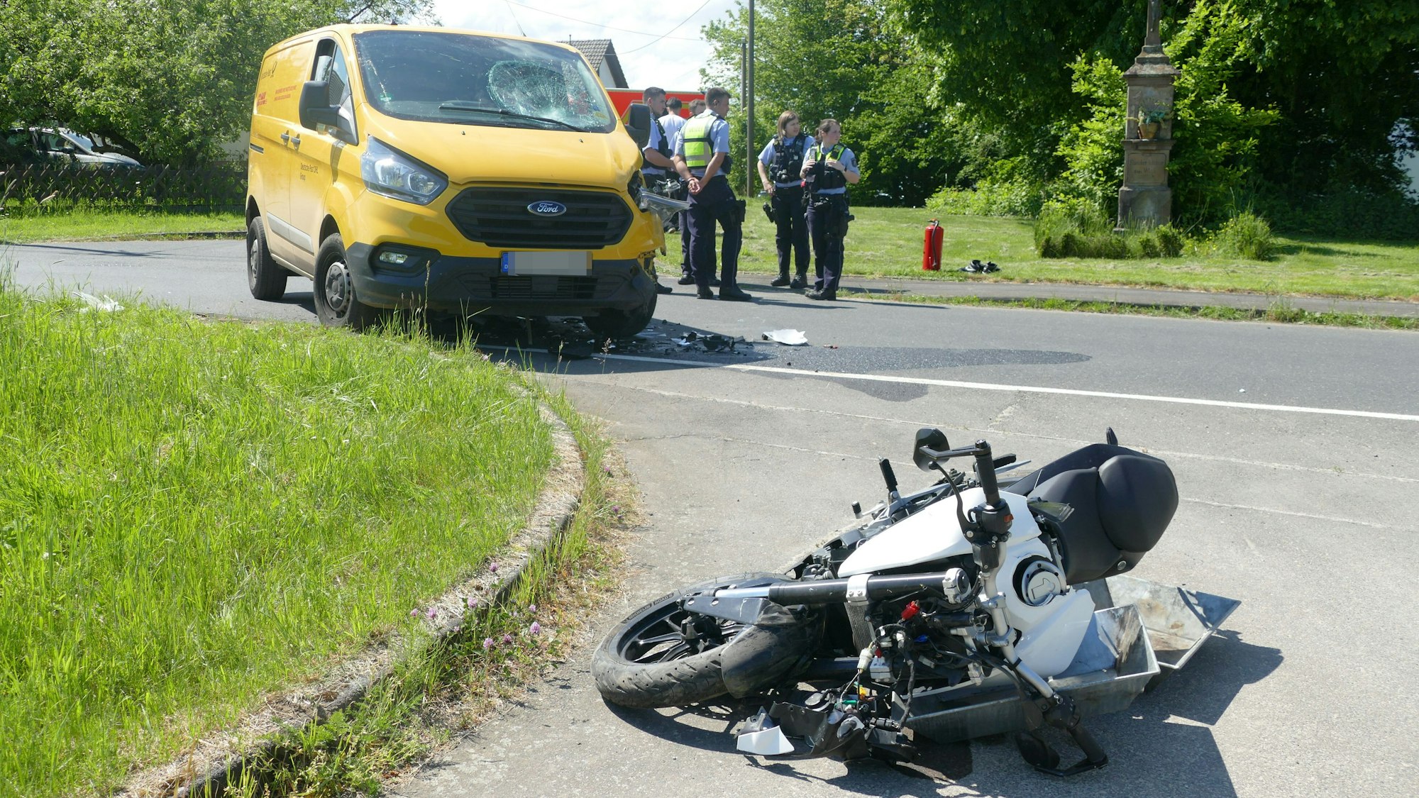 Das Motorrad liegt auf der Seite. Im Hintergrund ein gelber Transporter und Polizeibeamte.