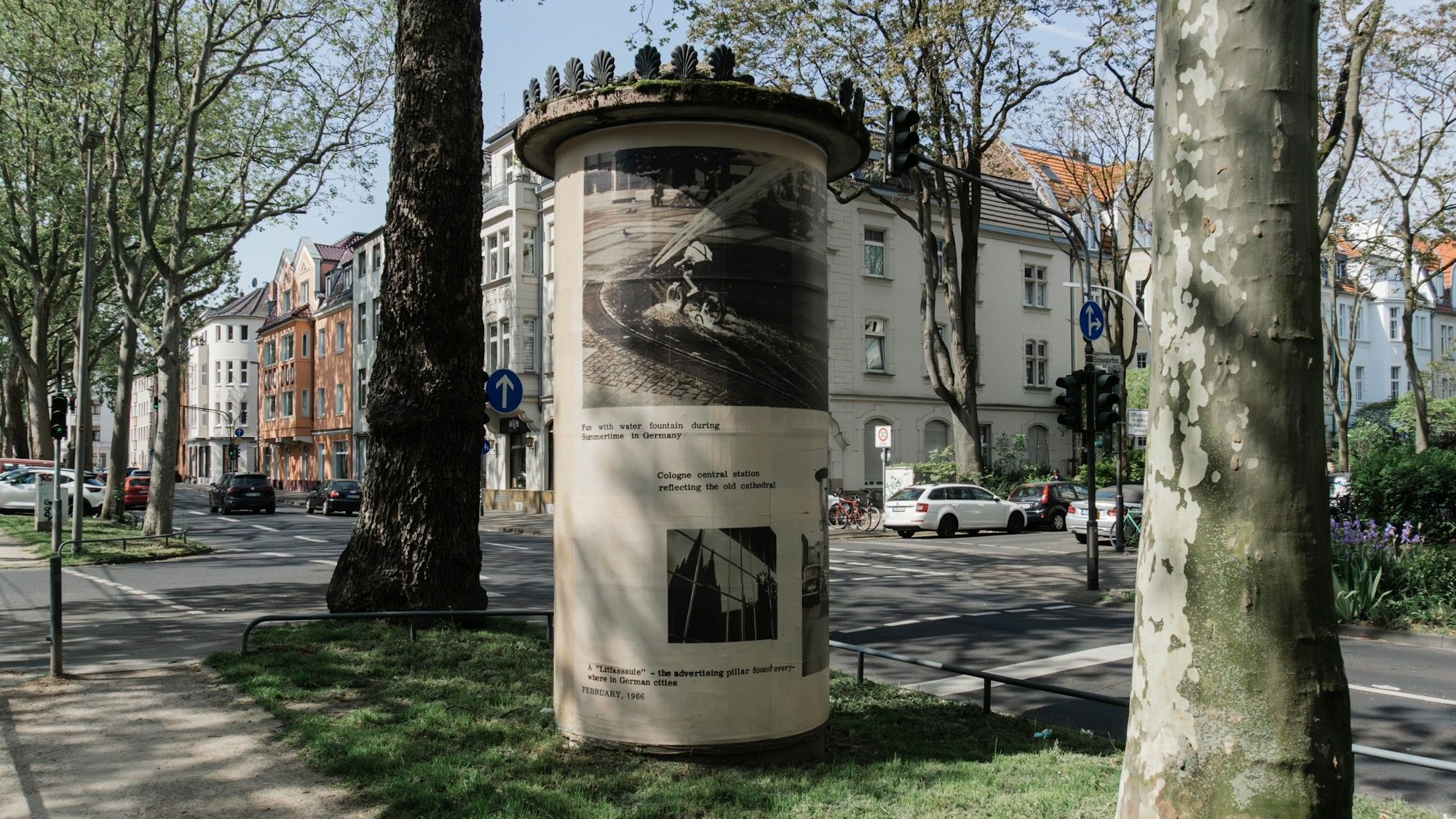 Zu sehen ist eine Litfaßsäule auf einem Grünstreifen.