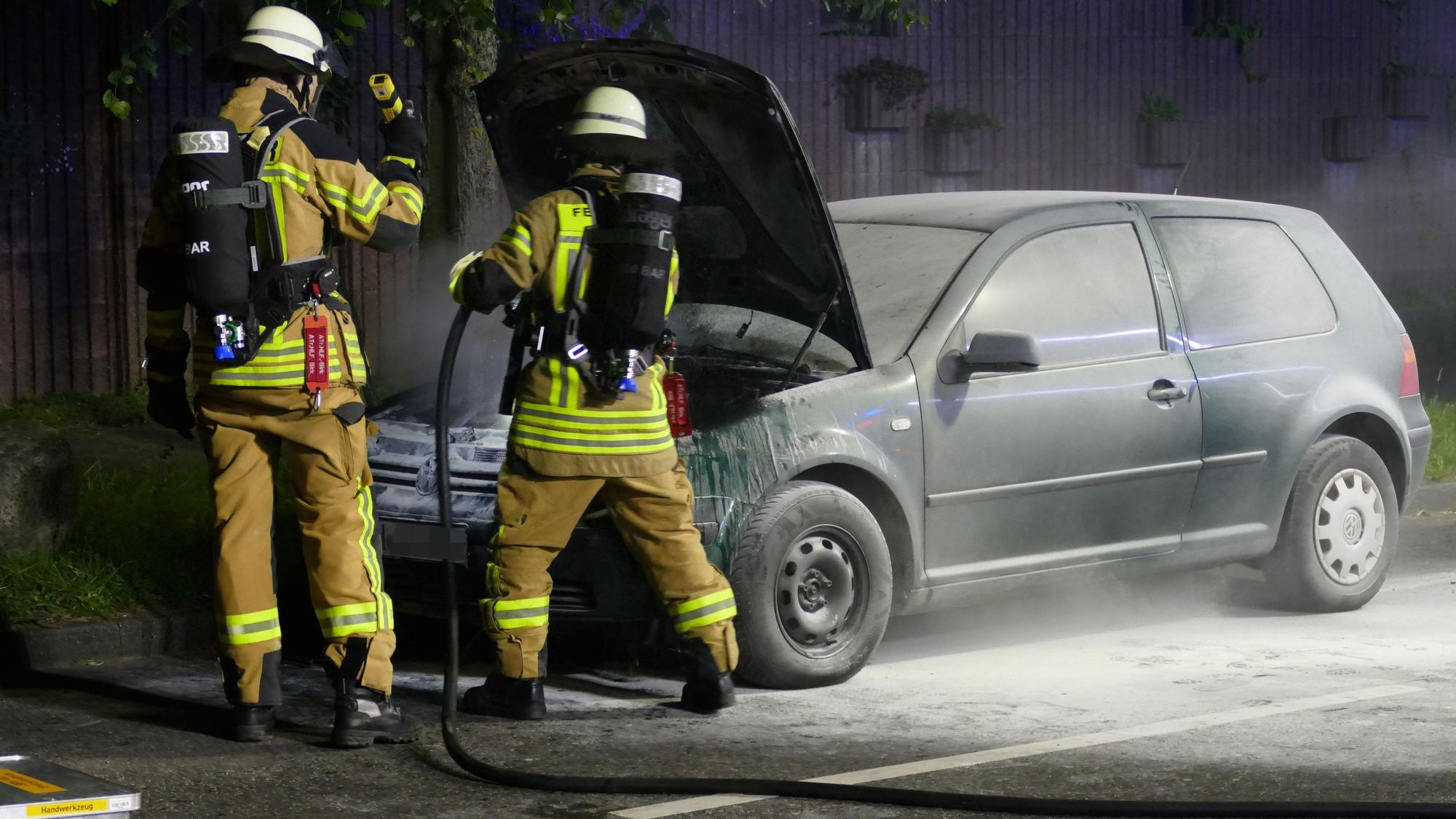 Feuerwehrleute löschen mit einem Schnellangriffsschlauch nach.