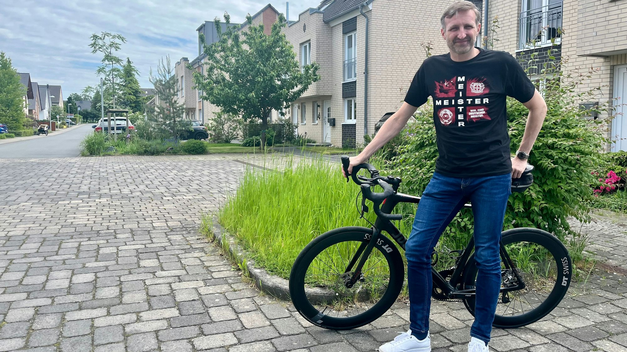 Mann mit Fahrrad an einer Straße