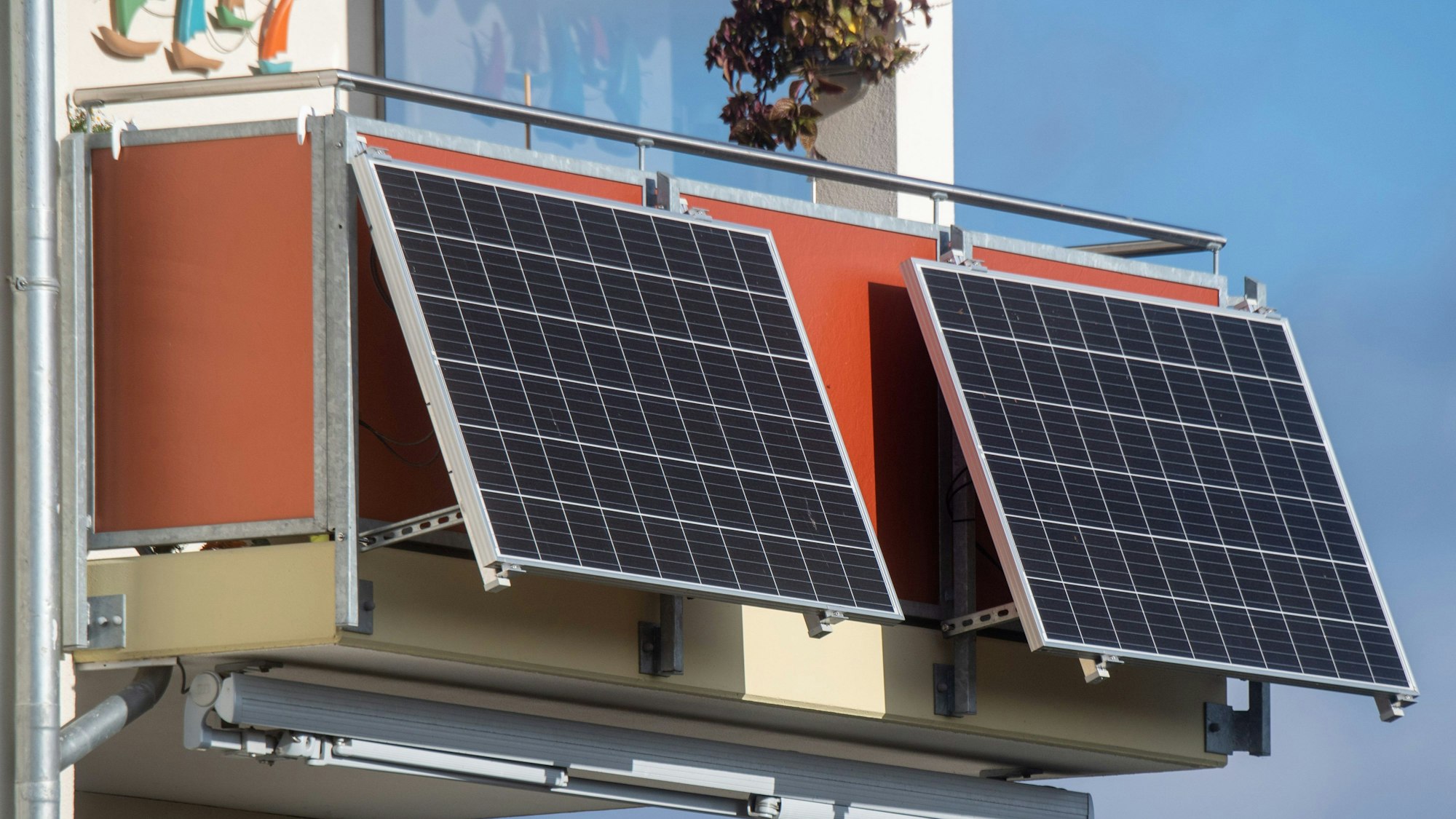 Solarmodule für ein sogenanntes Balkonkraftwerk hängen an einem Balkon.