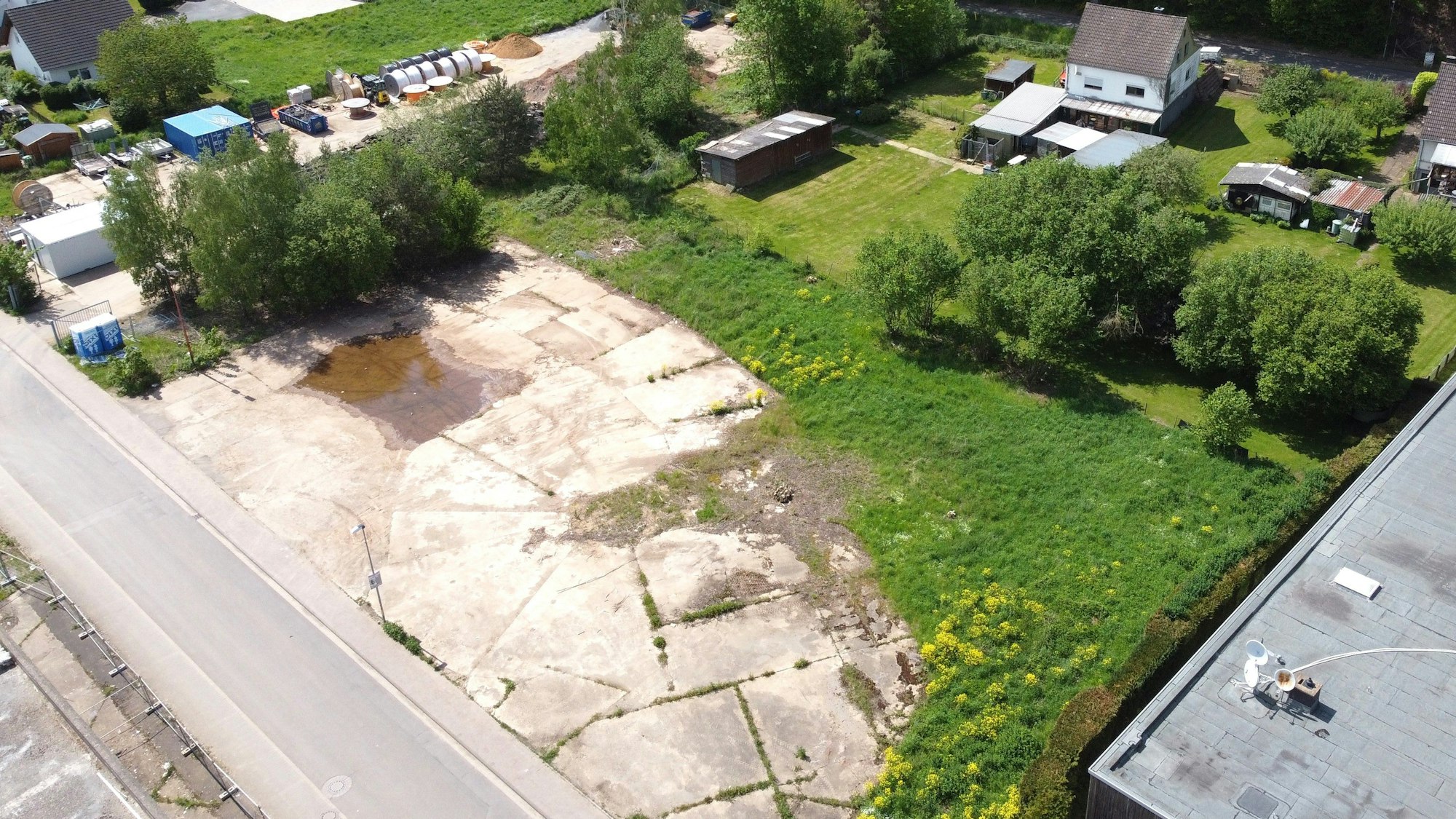 Blick von oben auf die Grundstücke, die zum Teil mit Betonplatten versiegelt sind.
