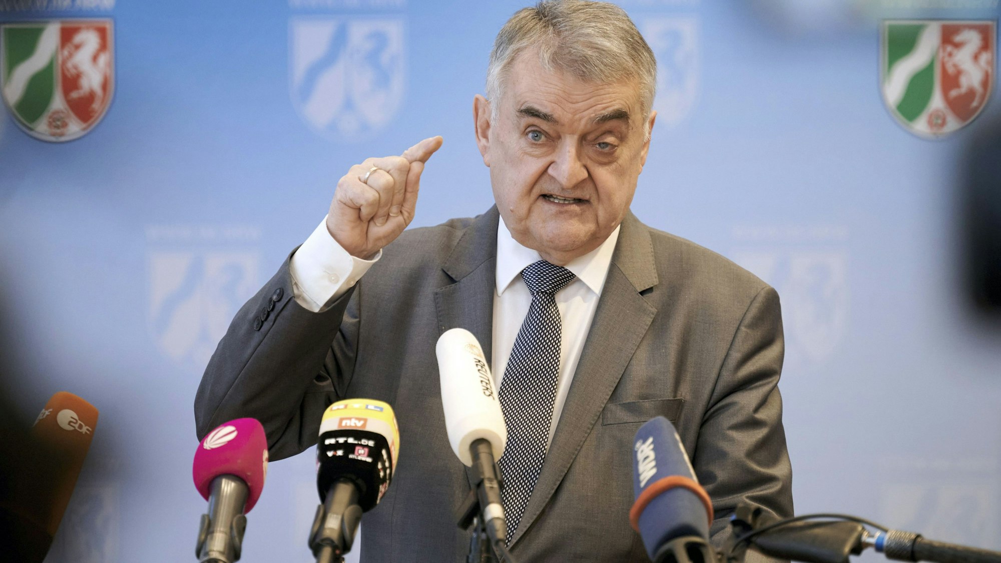 Herbert Reul, Innenminister des Landes Nordrhein-Westfalen (CDU), spricht bei einer Pressekonferenz. Er ist hinter mehreren Mikrofonen zu sehen.