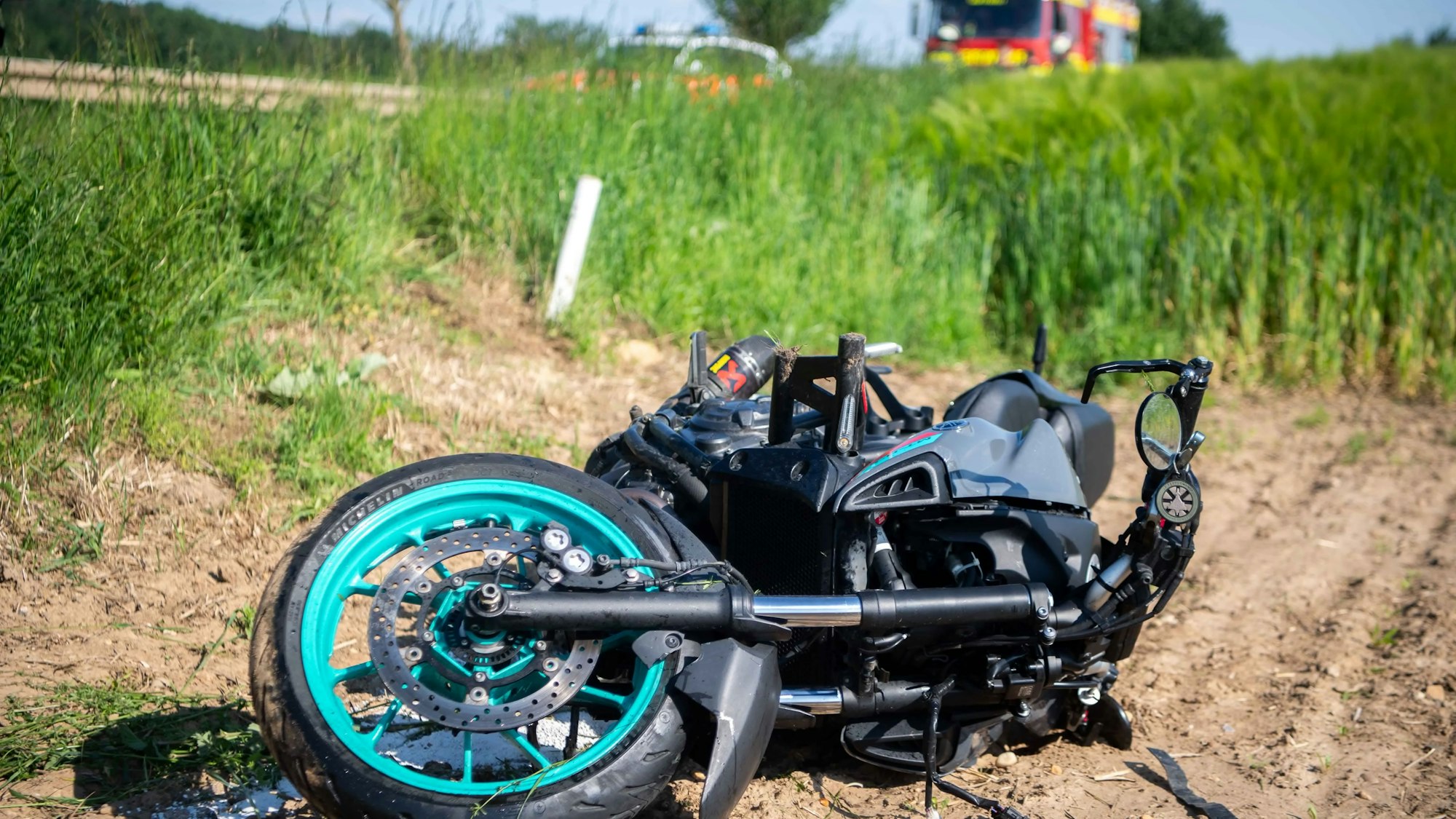 Das Bild zeigt das stark beschädigte Motorrad, das im Feld liegt.