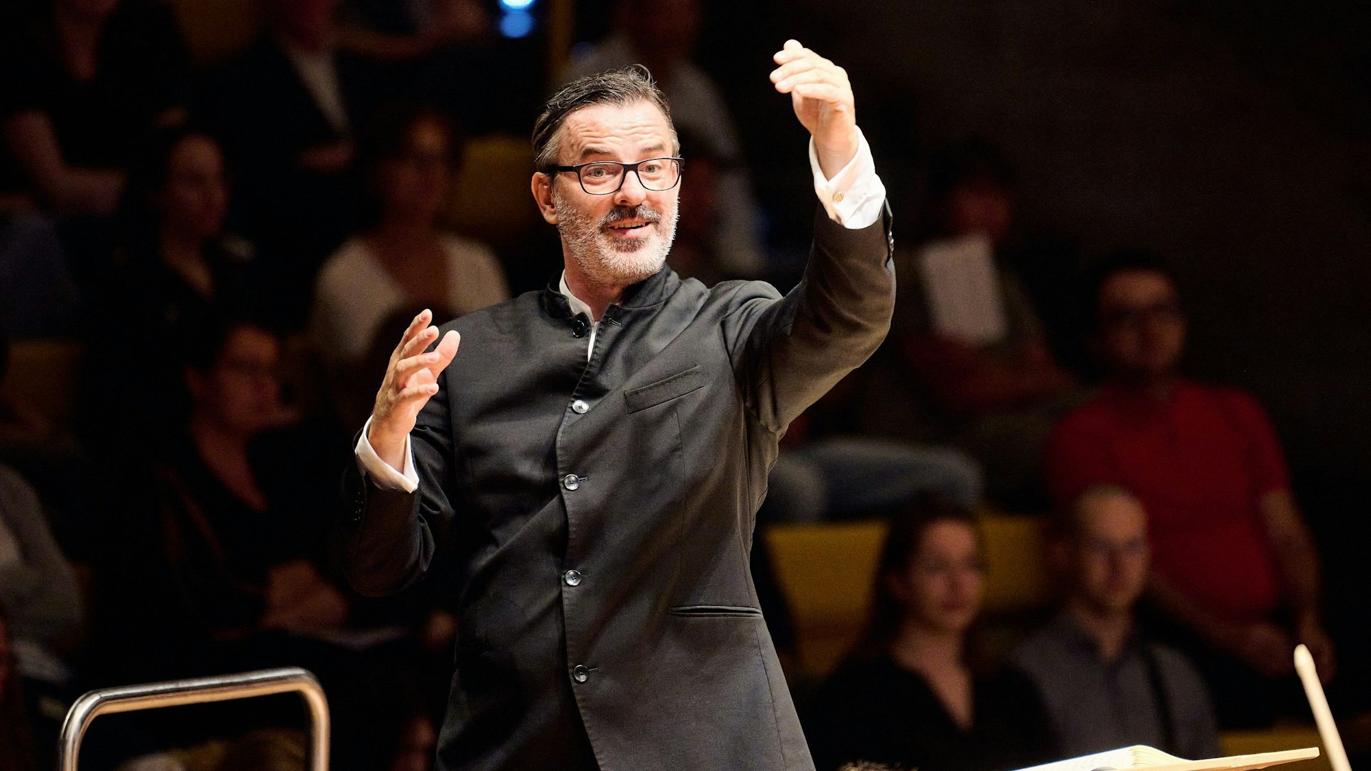 Zu sehen ist Michael Ostrzyga, der ein Konzert dirigiert.