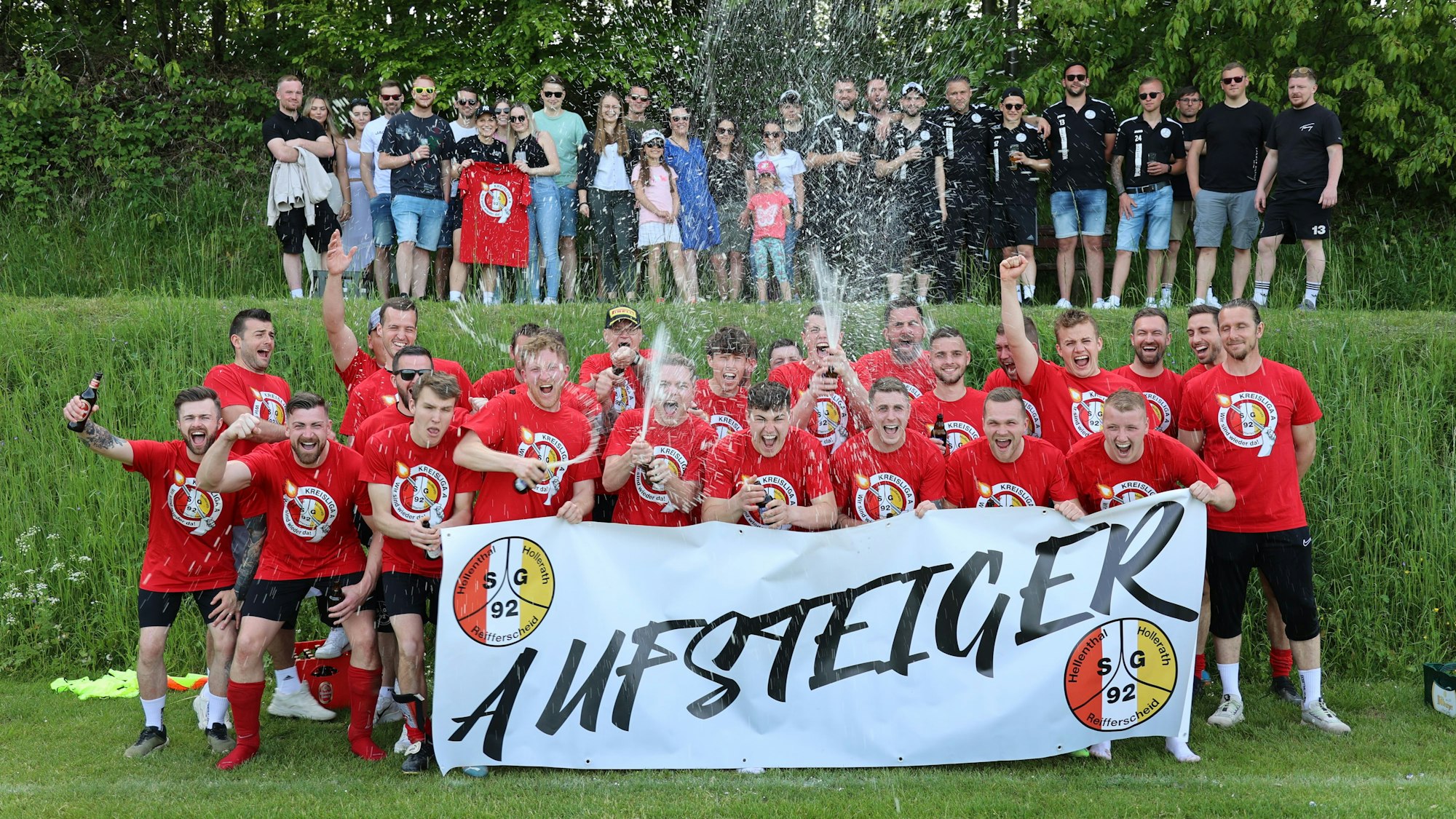 Eine Fußballmannschaft feiert den Aufstieg und lässt das Bier spritzen.