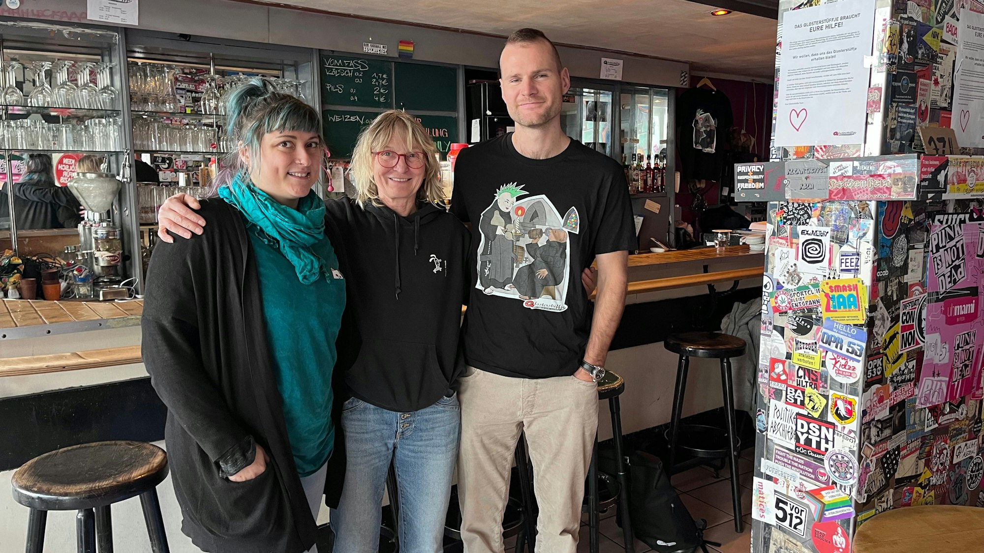 Miriam Bär, Wirtin Sabine Baumgart und Marius Lambertz vom „Qlosterstüffje“ stehen vor der Theke