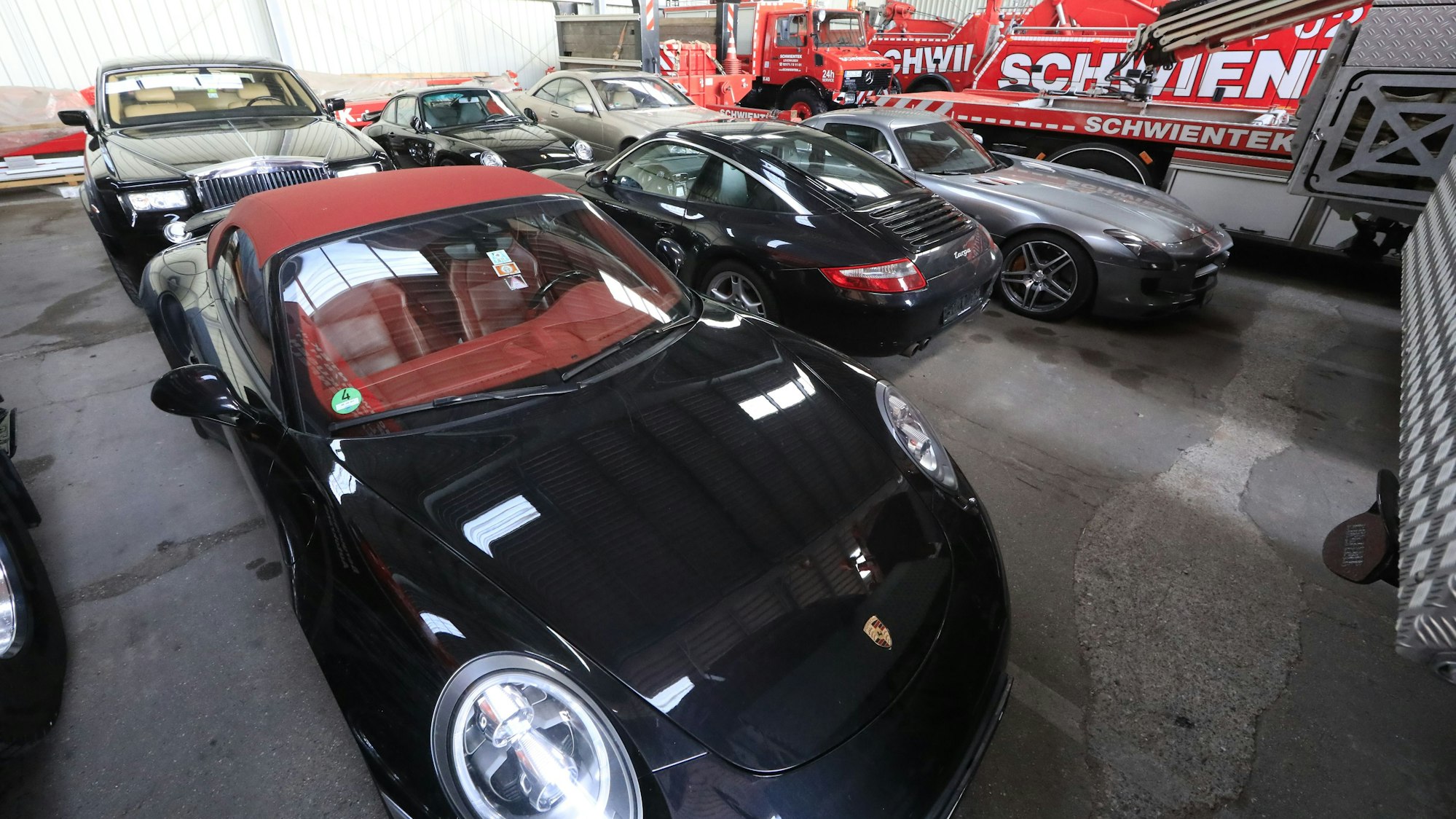 Porsche, Rolls-Royce, Mercedes der Leverkusener Großfamilie in einer Halle des Abschleppunternehmens Schwientek