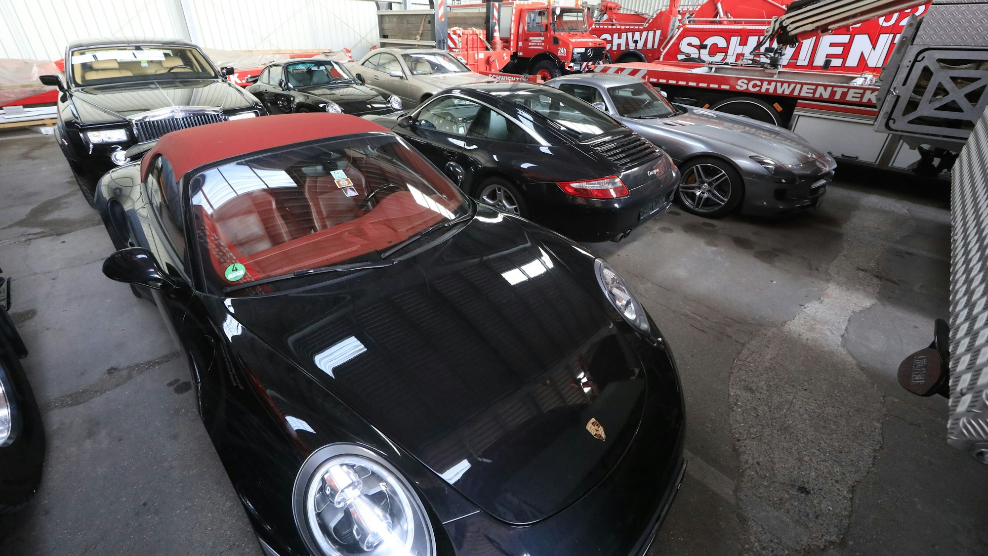 Porsche, Rolls-Royce, Mercedes der Leverkusener Großfamilie in einer Halle des Abschleppunternehmens Schwientek